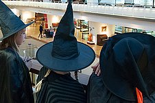 Drei als Hexen verkleidete Kinder schauen in den Ausstellungsraum des Musikinstrumenten-Museums