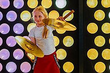 Kind mit Becken vor buntem Fenster in der Philharmonie