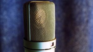 Silver microphone against a blue background