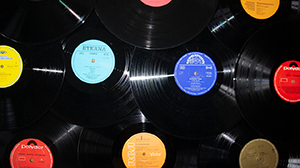 Black long-playing records stacked on top of each other, with colourful labels