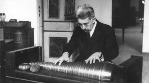 Black and white photo showing a man playing a glass harmonica