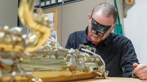 Restaurator bei der Arbeit an einem Instrument