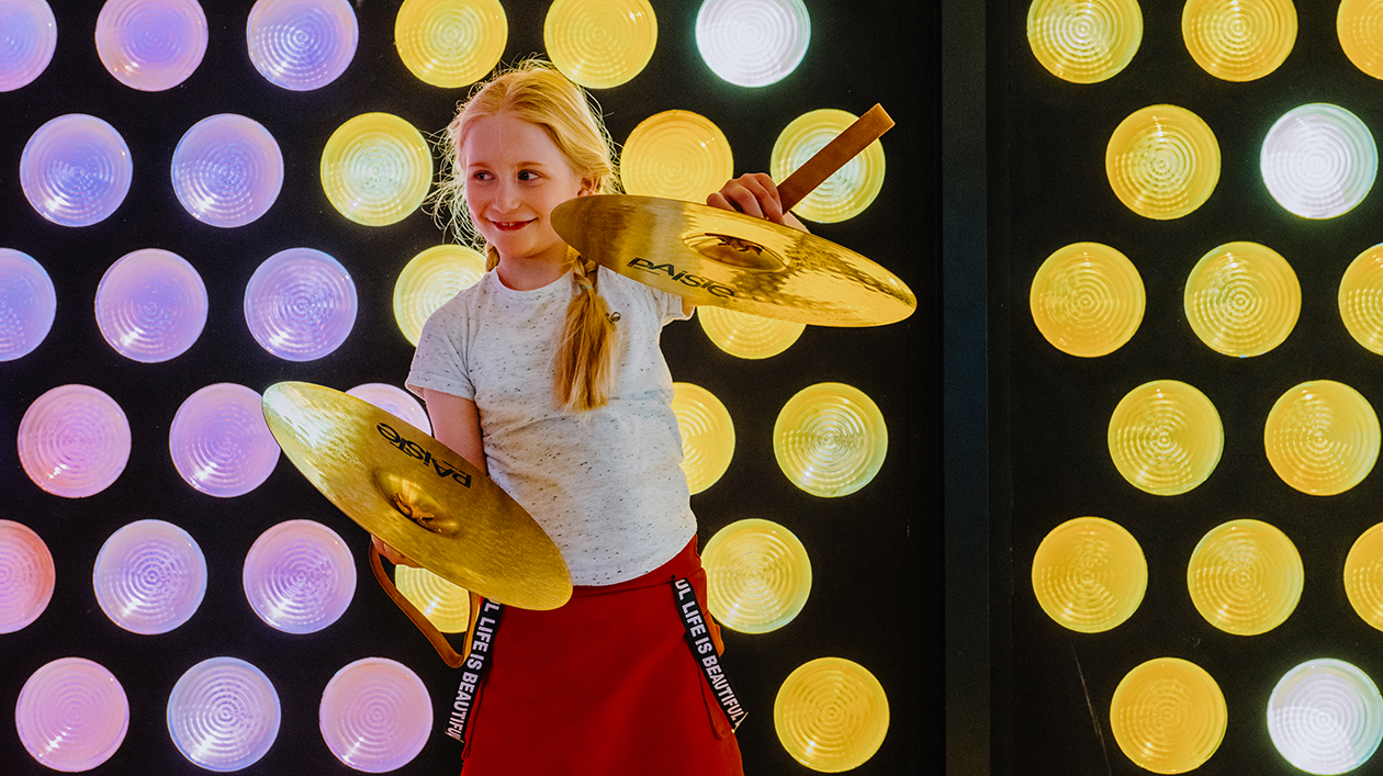 Kind bei Führung in der Philharmonie. Foto: Madlen Krippendorf Kind mit Becken vor buntem Fenster in der Philharmonie