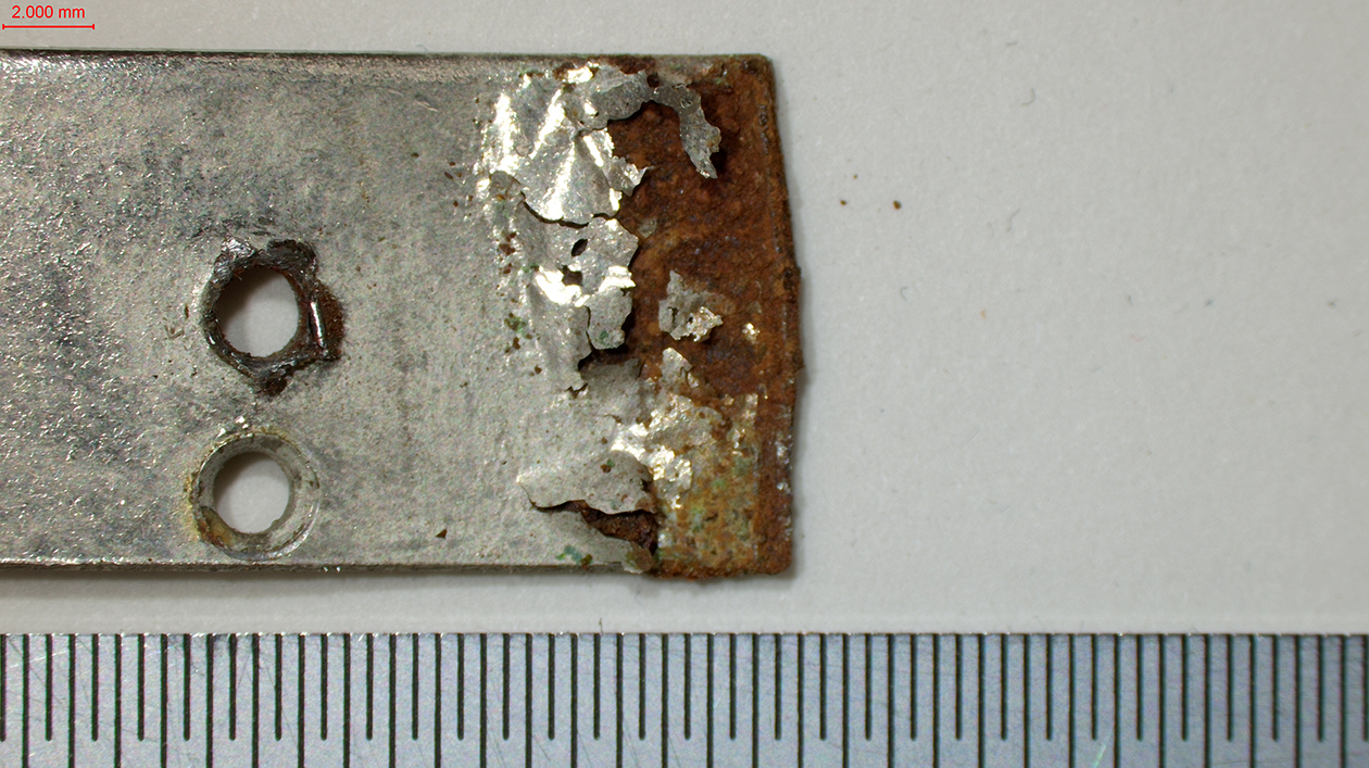 Detailaufnahme, Schadensbild an einem Verbindungsteil aus Metall, "Trickgitarre" Kat.-Nr. 5649
