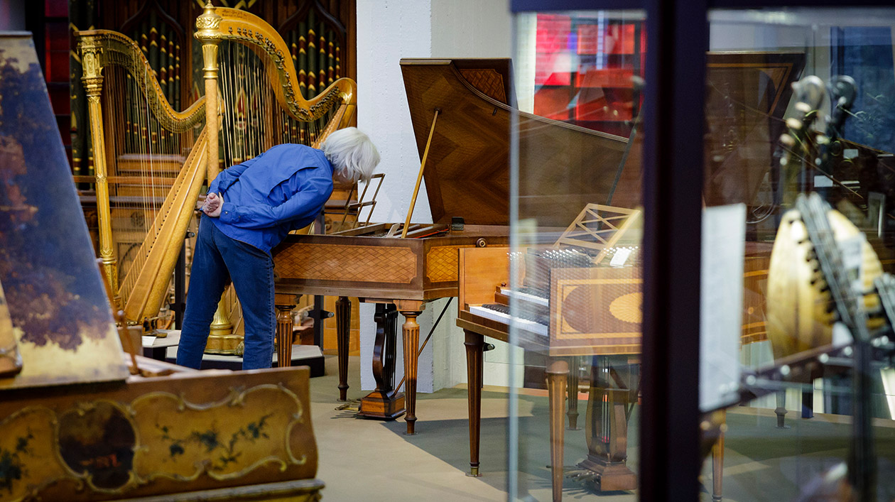 Besucher im Museum bei der Betrachtung eines Cembalos.