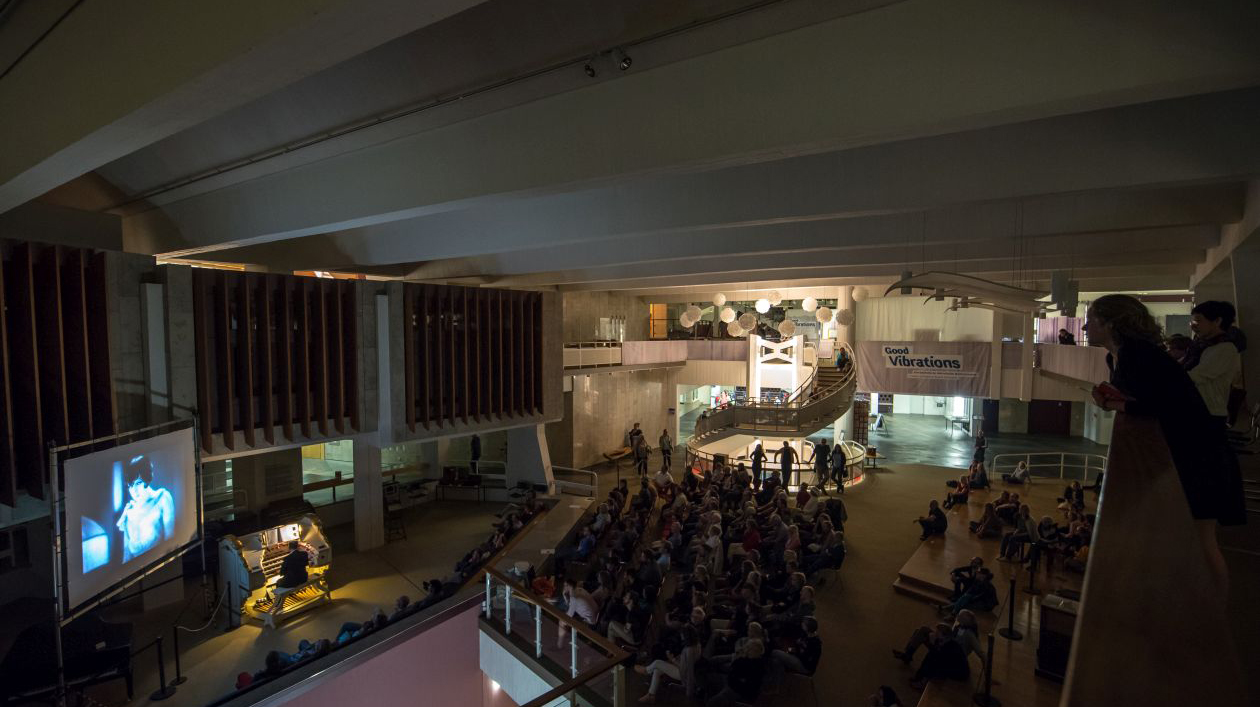 Organist and screen in dark cinema with audience